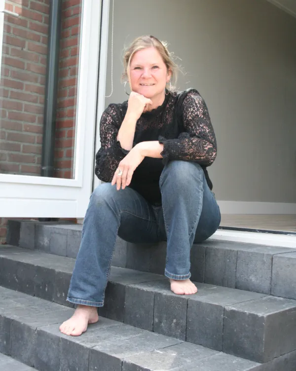 Susan van Susans Verademing zit blootsvoets op het trapje voor haar praktijk