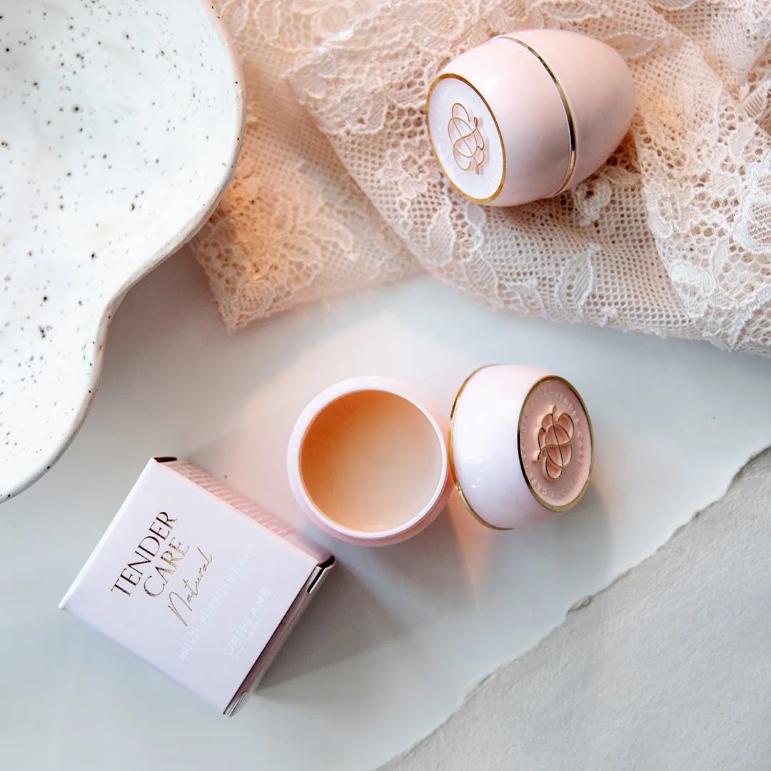 Lippenbalsem en verzorgingsproducten van Oriflame op een lichte ondergrond met kant