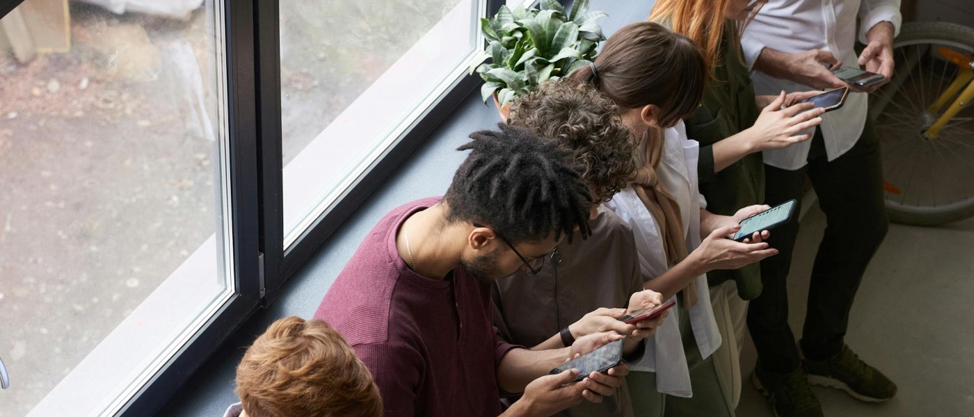 Meerdere mensen met hun telefoon in de hand en druk bezig op hun mobiele telefoon. Dit slaat op mobiele website blog door rscreate